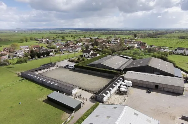 Aerial view of the outdoor arena with the village of Burtle behind