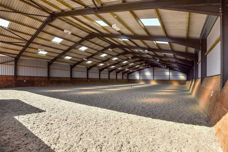 The indoor arena at Hill Farm, lit by roof lights
